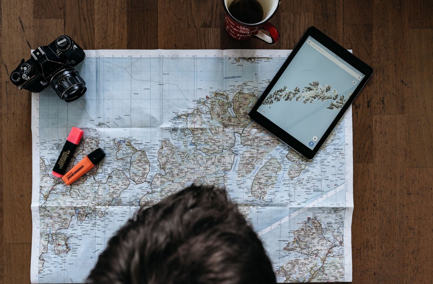 Person looking at a map of the norwegian coast, photo: Simon Migaj, Unsplash