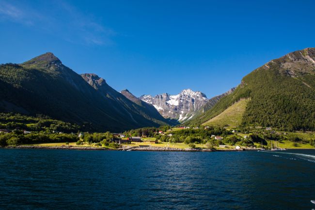 A small hamlet under high mountains in Hjørundfjorden: Photo: AdobeStock