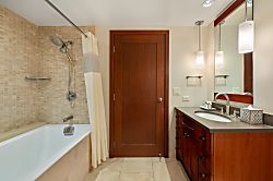 Beach Villas at Ko Olina O-1402 - Warm, well-lit second bathroom with a spacious vanity and a bathtub.