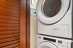 Beach Villas at Ko Olina O-1402 - A laundry nook with a stacked washer-dryer.