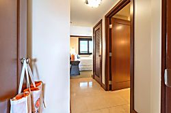 Beach Villas at Ko Olina O-1604 - Just beyond the hallway's soft glow lies your private haven—framed in rich wood, calm ligh