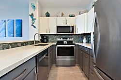 Napili Point B5 - A well-designed kitchen showcasing custom two-tone cabinetry, colorful glass mosaic backsp