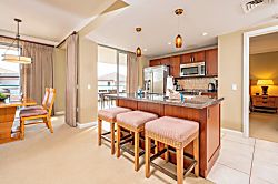 Honua Kai Hokulani 620 - Island kitchen and dining area with balcony light and cozy comfort.