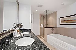 Honua Kai Konea 334 - Modern bathroom with granite vanity, glass shower, and soaking tub