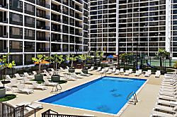 Waikiki Banyan 3313 Tower 1 - Modern outdoor pool area with ample lounge seating and nearby tennis courts in a residenti