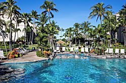 Aston Kaanapali Shores 2BO2 - A sparkling swimming pool surrounded by lush tropical palms and vibrant gardens, with sun