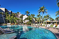 Aston Kaanapali Shores 1Br - Resort-style pool surrounded by tropical palms, tiki huts, and modern buildings set agains