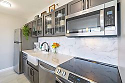 Waikiki Banyan 3401 T2 - Modern kitchen with stainless steel appliances and glass-front cabinets