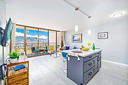 Waikiki Banyan 3401 T2 - Bright living area with modern kitchen island and balcony overlooking mountain views