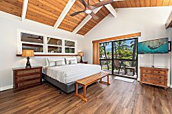 Kanaloa at Kona 1606 - The primary suite rises under vaulted wood beams, its own lanai just off the room.