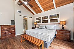 Kanaloa at Kona 1606 - A king bed under the peak of the ceiling, a sliding barn door alongside.