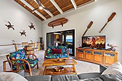 Kanaloa at Kona 1606 - Vaulted wood-beam ceilings give the living room room to breathe, tropical prints and all.