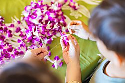 Aston Kaanapali Shores 619 - Staff members craft traditional floral lei using vibrant purple and white orchids, creatin