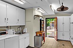 Kulakane 105 - Shared laundry area featuring folding space and guest conveniences.