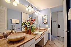 Papakea A301 - Refresh in a bright bathroom with dual vessel sinks and tropical accents.