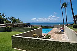 Shores of Maui 109 - A serene pool framed by stone tiles and tropical plants, with the ocean stretching out jus