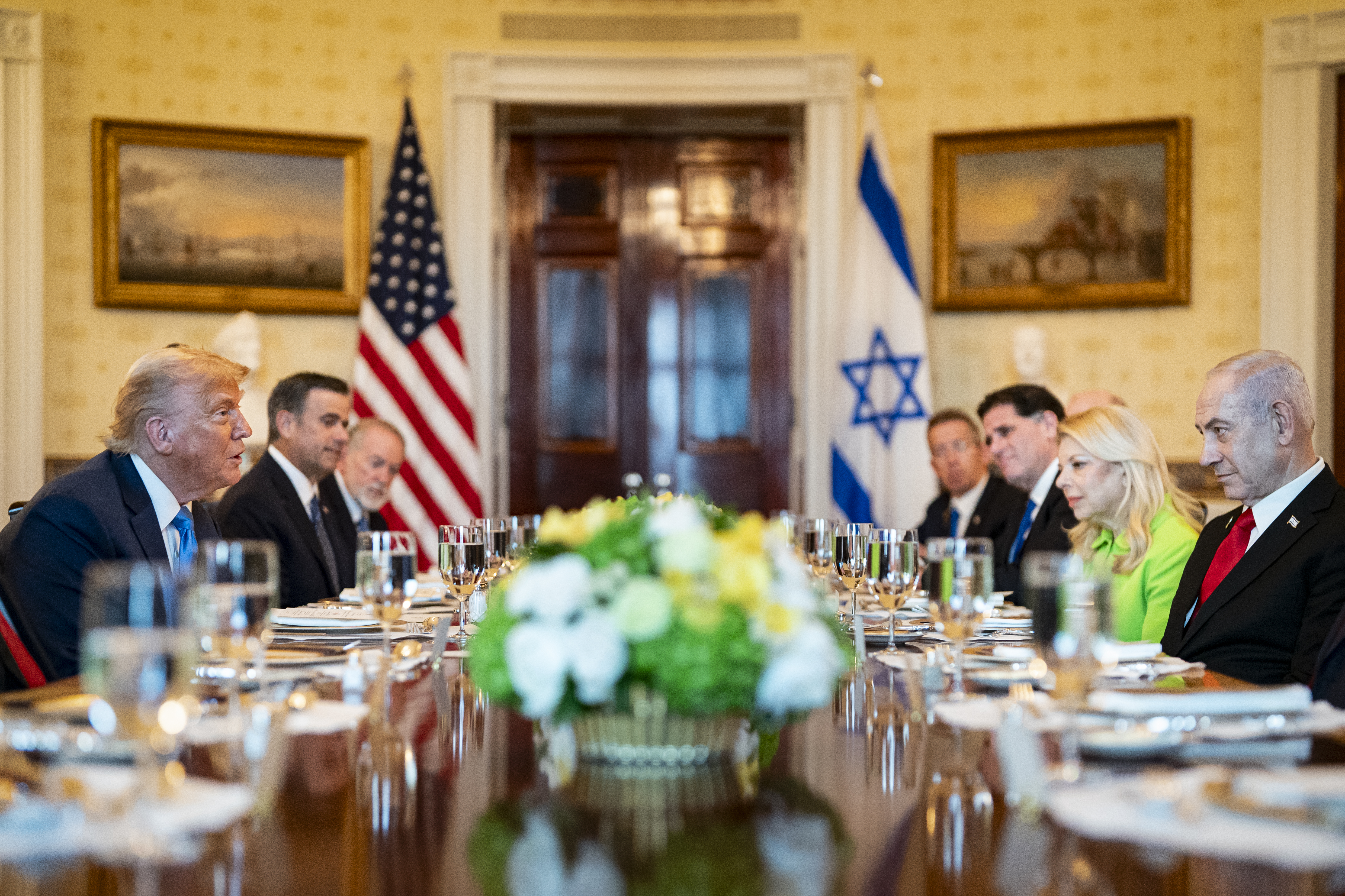 Mike Huckabee, ambassadeur américain en Israël, à droite, John Ratcliffe, directeur de la Central Intelligence Agency (CIA), au centre, lors d'un dîner avec le président américain Donald Trump, à gauche, et le Premier ministre israélien Benjamin Netanyahu, non représenté, dans la Salle bleue de la Maison Blanche à Washington, DC, États-Unis, le lundi 7 juillet 2025. Photographe : Al Drago/Pool/Sipa USA