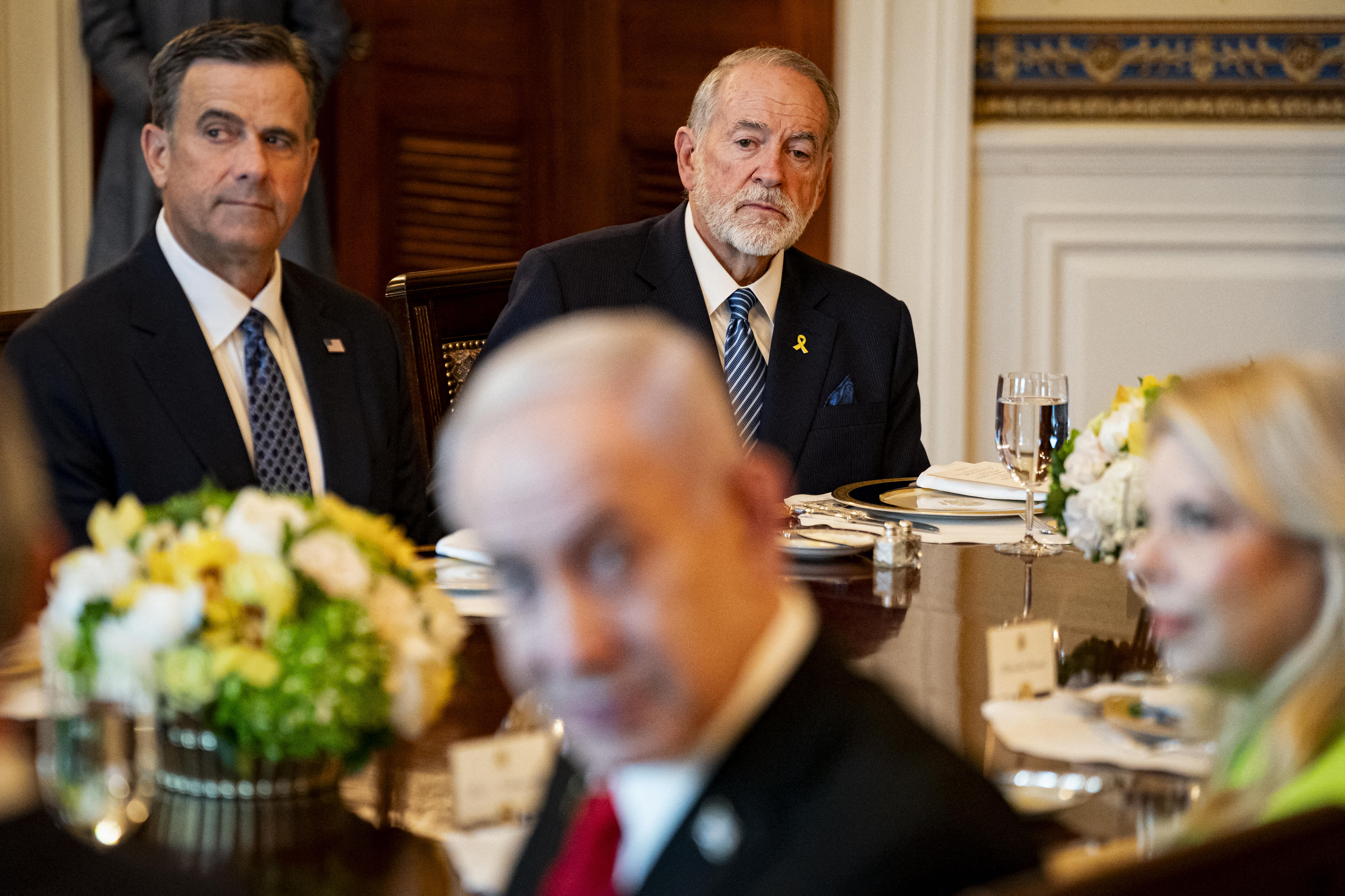 Mike Huckabee, ambassadeur américain en Israël, à droite, John Ratcliffe, directeur de la Central Intelligence Agency (CIA), au centre, lors d'un dîner avec le président américain Donald Trump, à gauche, et le Premier ministre israélien Benjamin Netanyahu, non représenté, dans la Salle bleue de la Maison Blanche à Washington, DC, États-Unis, le lundi 7 juillet 2025. Photographe : Al Drago/Pool/Sipa USA