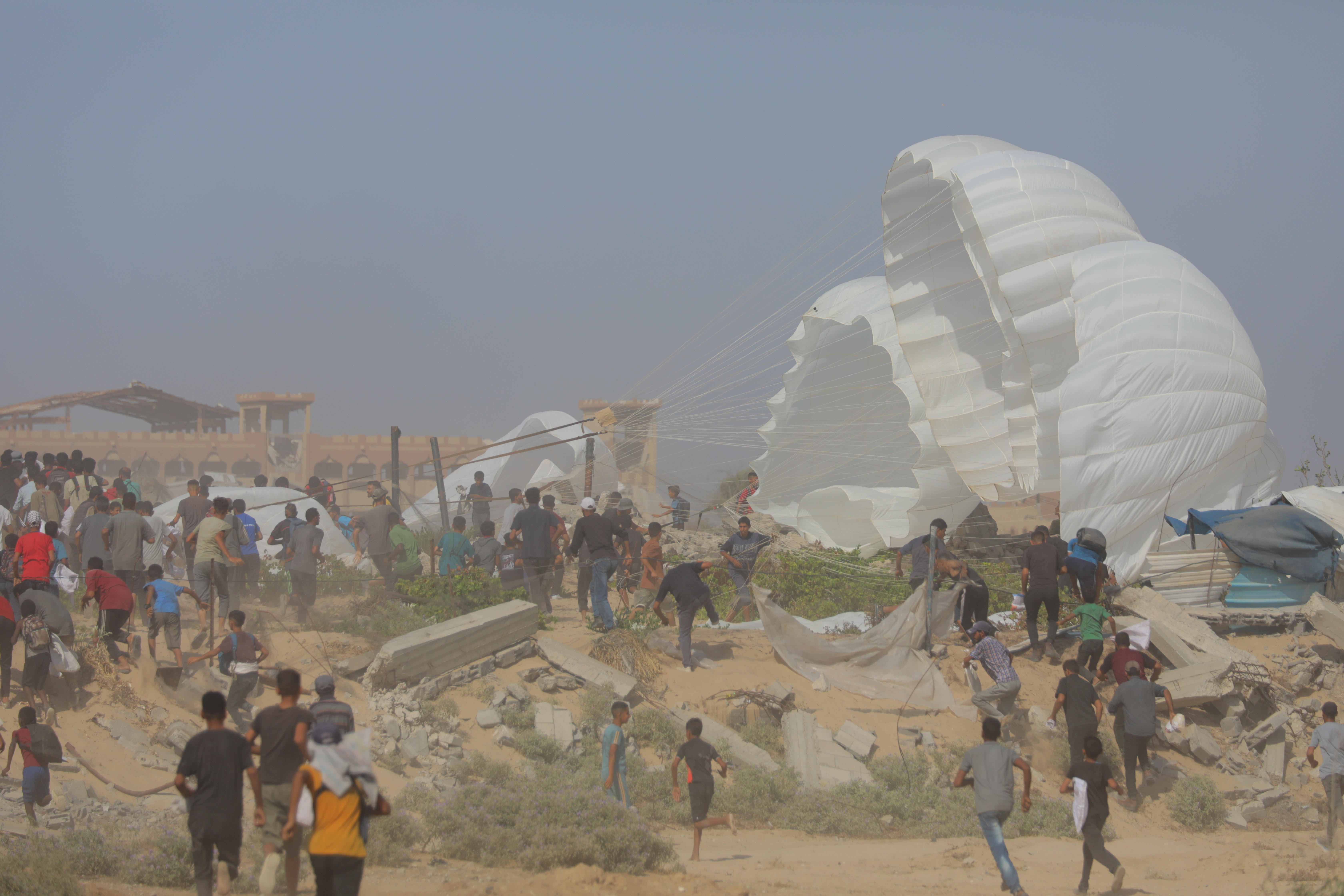 Displaced Palestinians carry food parcels and supplies from a GHF aid distribution point at the “Netzarim corridor” in the central Gaza, August 5, 2025. (Photo: Ali Hassan/Flash90)