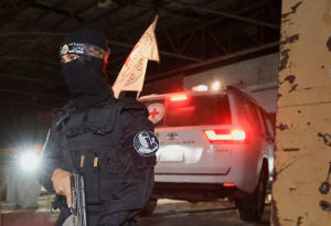 An armed Hamas militant stands guard as a Red Cross vehicle arrives to receive from Hamas militants the bodies of deceased hostages who had been held in Gaza since the deadly October 7, 2023 attack, as part of a ceasefire and a hostages-prisoners swap deal between Hamas and Israel, in Gaza City, October 14, 2025. (Photo: REUTERS/Dawoud Abu Alkas)