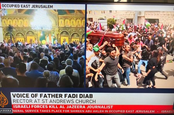 Family and friends carry the coffin of Al Jazeera reporter Shireen Abu Akleh, who was killed during an Israeli raid in Jenin in the occupied West Bank, as Israeli security forces stand guard, during her funeral in Jerusalem, May 13, 2022. (Photo: REUTERS/Ammar Awad)