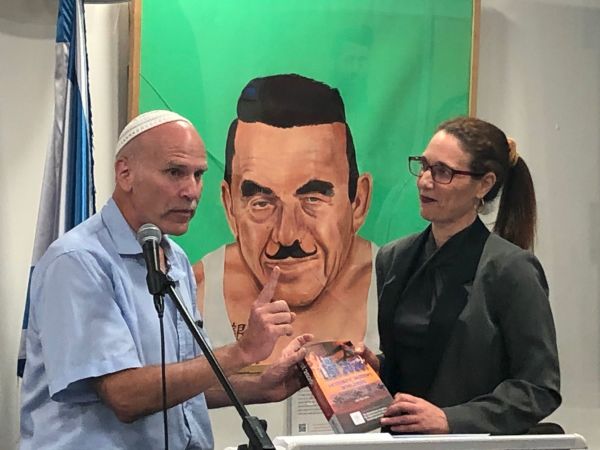 Gidon Ariel, executive director of Root Source, holding "The List 2020: Antisemitic Incidents Worldwide" and "The LIST: Persecution of Jews by Christians Throughout History" (Photo courtesy)