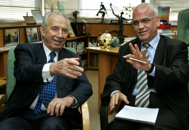 Then Israeli Deputy Prime Minister and Vice Premier Shimon Peres (L) attend a meeting with Palestinian Authority negotiator Saeb Erekat in Tel Aviv October 14, 2005. (Photo: REUTERS/Gil Cohen Magen)