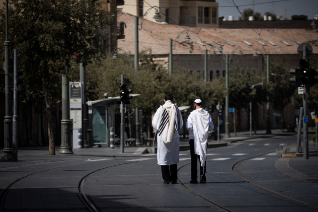 Jewish men pray on the light rail train tracks in Jerusalem on Yom Kippur, the Day of Atonement, Sept. 28, 2020. (Photo: Yonatan Sindel/Flash90)