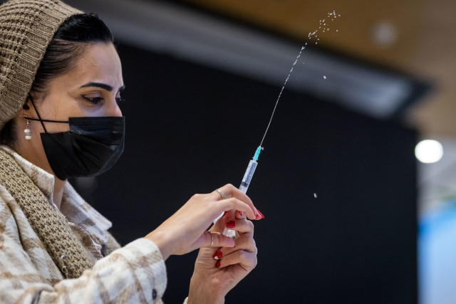 Israelis receives their dose of the COVID-19 vaccine at the Malcha Mall in Jerusalem, Dec. 23, 2021. (Photo: Olivier Fitoussi/Flash90)