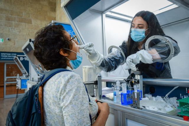 A medical technician tests a passenger for COVID-19 at Ben-Gurion International Airport, June 30, 2021. (Photo: Avshalom Sassoni/Flash90)