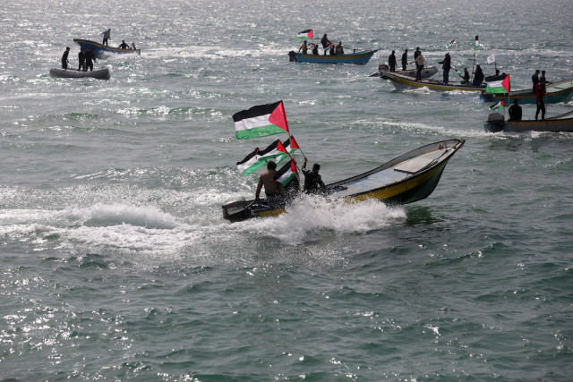 Palestinians hold their national flag as they ride boats during a rally marking the 46th anniversary of Land Day, at the seaport of Gaza City, March 30, 2022. (Photo: Majdi Fathi/NurPhoto via Reuters)