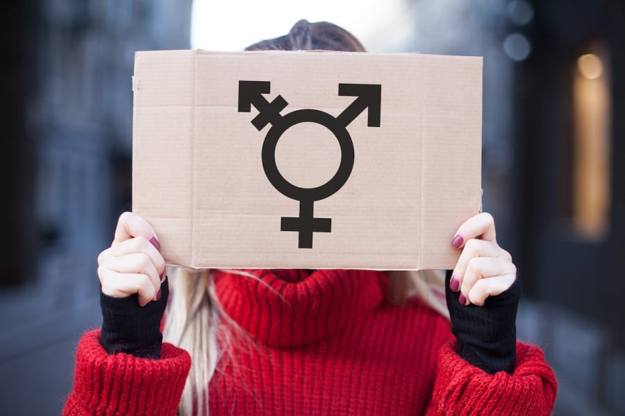Someone holding a cardboard plate with the transgender symbol (Photo: Shutterstock)