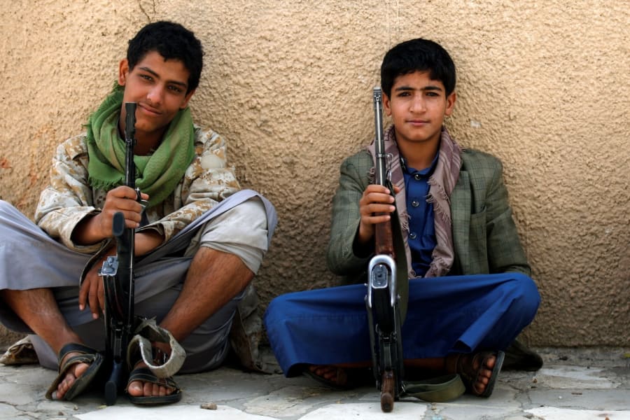Illustration - De jeunes militants houthis sont assis sur le bord d'une route alors qu'ils sécurisent une rue près des bureaux des Nations Unies où des enfants manifestaient contre le retrait de la coalition dirigée par l'Arabie saoudite de la liste noire annuelle des Nations Unies sur les droits de l'enfant, à Sanaa, au Yémen, le 15 juin 2016. (Photo : REUTERS/Khaled Abdullah)