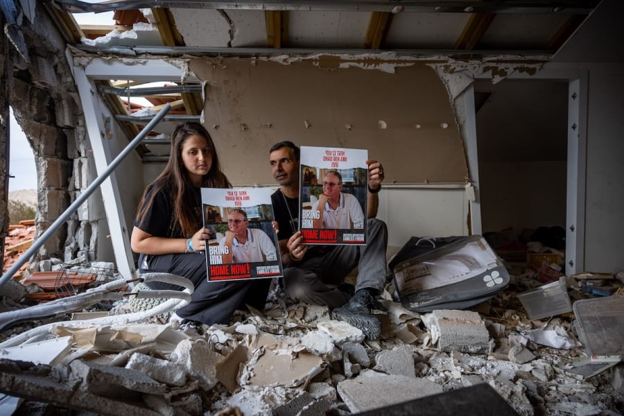 Ella Ben Ami whose father was kidnapped by Hamas terrorists in the Gaza Strip and Ohad's brother pose for a picture at the destroyed family home in Kibbutz Be'eri near the Israeli-Gaza border, southern Israel, December 20, 2023. (Photo: Yonatan Sindel/Flash90)