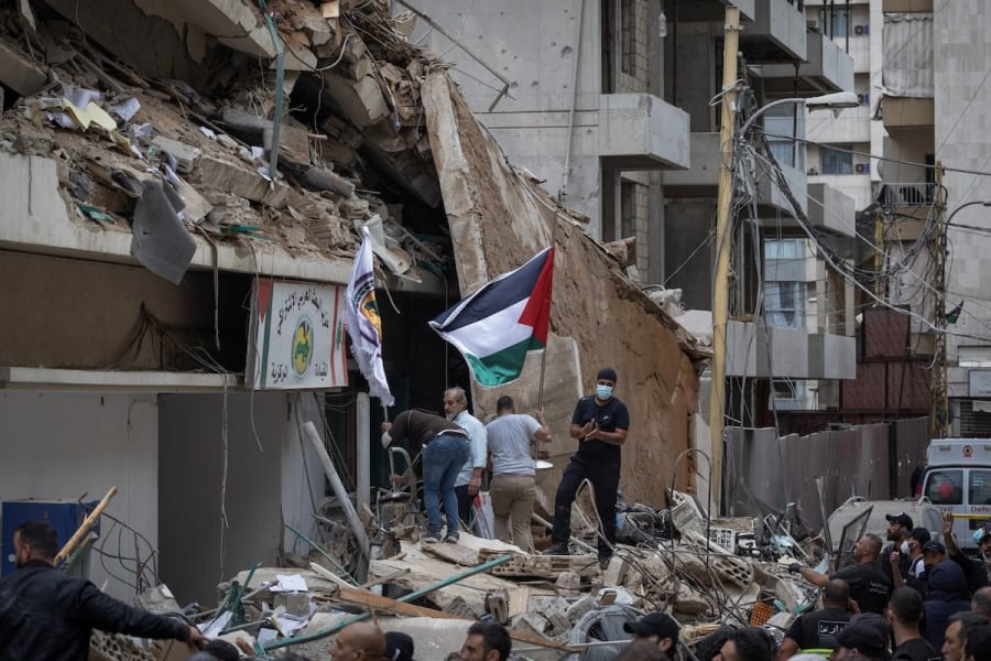 People stand on the rubble after an Israeli strike on a building that, according to security sources, killed Hezbollah's media relations chief Mohammad Afif, in Ras Al-Nabaa, in Beirut, Lebanon Nov 17, 2024. REUTERS/Adnan Abidi