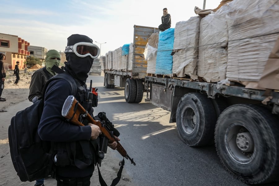 Bewaffnete und maskierte Palästinenser sichern Lastwagen mit humanitärer Hilfe, die über den israelischen Grenzübergang Kerem Shalom an der Salah al-Din Road östlich von Khan Yunis im südlichen Gazastreifen einfahren, 19. Januar 2025. (Foto: Abed Rahim Khatib/Flash90)