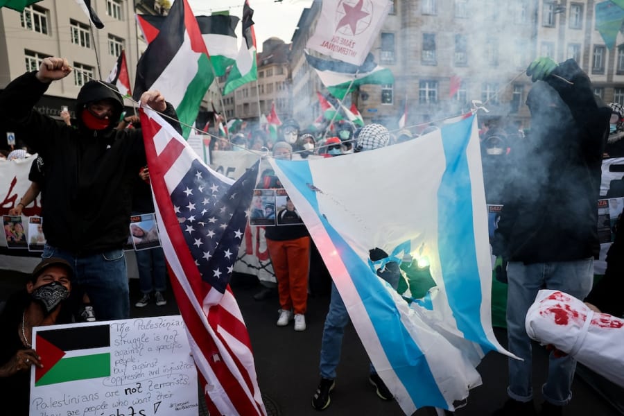 Pro-Palestinian demonstrators burn representations of the U.S. and Israeli flags during a protest, on the day of the Grand Final of the 2025 Eurovision Song Contest in Basel, Switzerland, May 17, 2025. (Photo: REUTERS/Christian Hartmann)