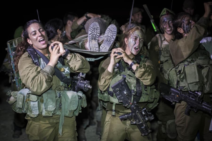 Illustrative - Female IDF soldiers of the Caracal Battalion seen cheering while carrying a fellow soldier on a stretcher at the end of their 16 Kilometer journey to complete their training course, in Tel Nitzan, southern Israel, near the border with Egypt, September 3, 2014. (Photo: Hadas Parush/Flash90)