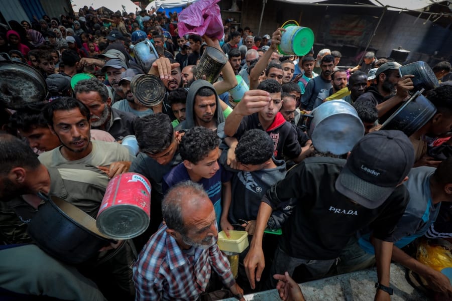 Des Palestiniens reçoivent des repas de la part de bénévoles dans la ville de Gaza, le 21 mai 2025. (Photo : Ali Hassan/Flash90)