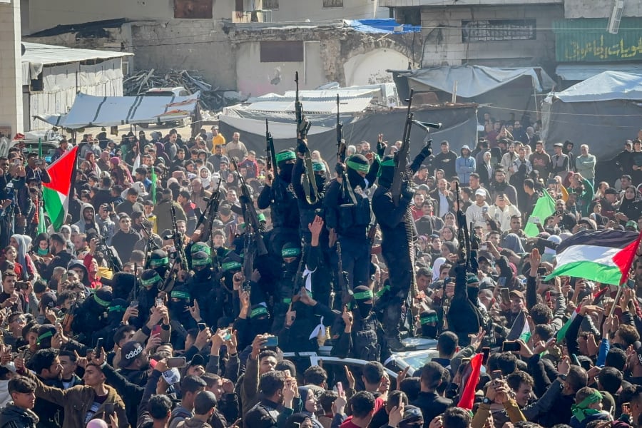 Al-Qassam Brigades, the military wing of Hamas, hand over four Israeli hostages to the Red Cross in Palestine Square, in Gaza City, Jan. 25, 2025. (Photo by Ayman Alhesi/Flash90)