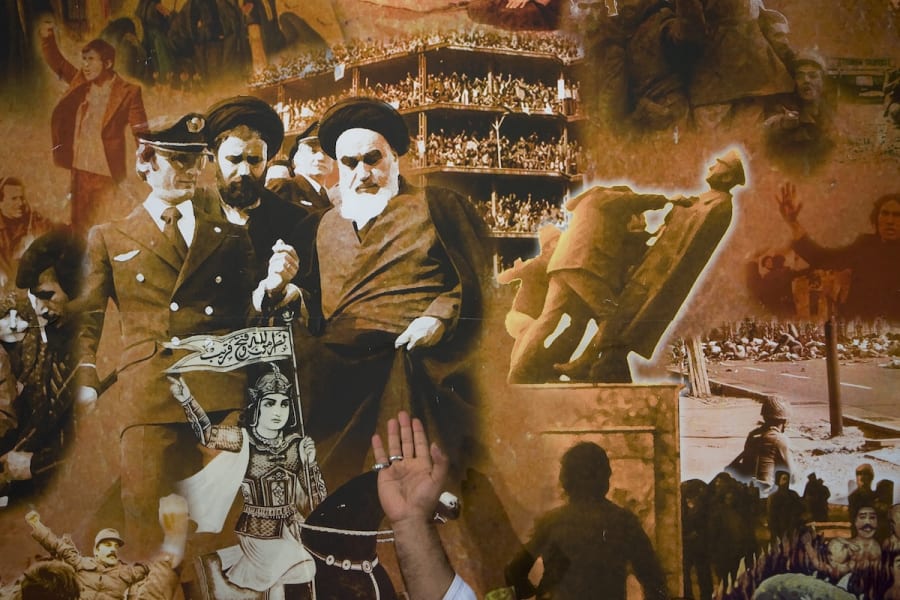 A man gestures in front of a poster at the anniversary ceremony of Iran's Islamic revolution at the Khomeini shrine in the Behesht Zahra cemetery, south of Tehran, January 31, 2009. (Photo: REUTERS/Morteza Nikoubazl (IRAN)