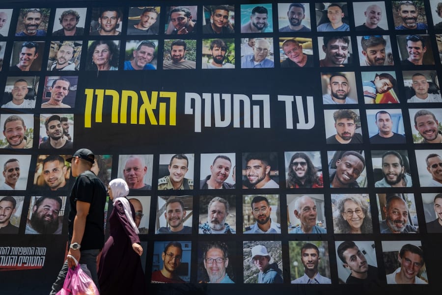 Des personnes passent devant des photographies d'Israéliens pris en otage par des terroristes du Hamas à Gaza, dont certains ont été libérés, à Jérusalem, le 3 juillet 2025. (Photo : Yonatan Sindel/Flash90)