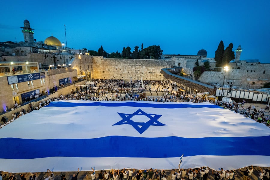 People hold a giant Israeli national flag at the Western Wall in Jerusalem Old City, on the eve of Jerusalem Day, May 25, 2025. (Photo: Chaim Goldberg/Flash90)