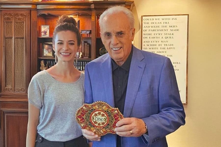 Angelina with John MacArthur with a piece of art with the word "Shalom" (Photo courtesy)
