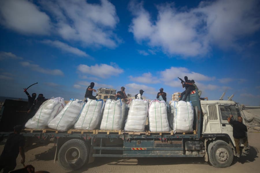 Illustration : Des Palestiniens armés s'assoient sur des camions transportant de l'aide humanitaire près du poste frontière de Zikim entre Israël et Beit Lahia dans le nord de la bande de Gaza, le 25 juin 2025. Photo : Ali Qariqa/Flash90