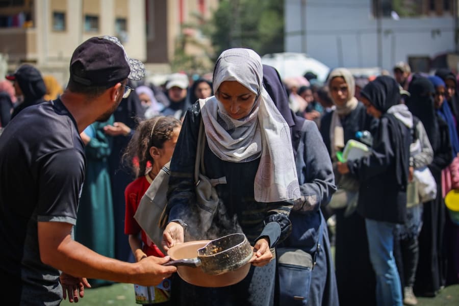 Palestinians receive meals from volunteers in Gaza City, July 25, 2025. (Photo: Ali Hassan/Flash90)