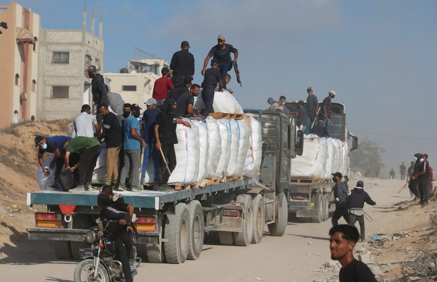 Illustration: Palestinians from clans hold guns and melee weapons to secure aid trucks in Beit Lahia, in the northern Gaza Strip, June 25, 2025. REUTERS/Mahmoud Issa