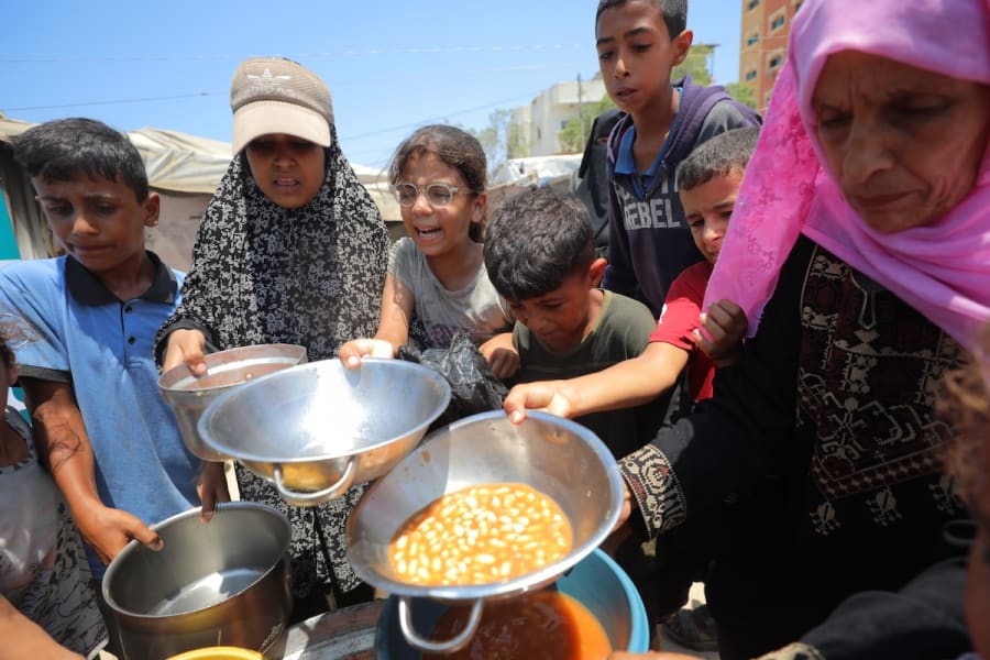 Palestinians receive meals from volunteers in Gaza City, July 28, 2025. (Photo: Ali Hassan/Flash90)