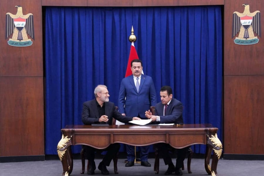 Iraqi Prime Minister Mohammed Shia al-Sudani looks on as Iraq's National Security Adviser Qasim al-Araji and Ali Larijani, secretary of Iran's Supreme National Security Council, sign documents in Baghdad, Iraq, August 11, 2025. (Photo: Iraqi Prime Minister’s Media Office/Handout via REUTERS)