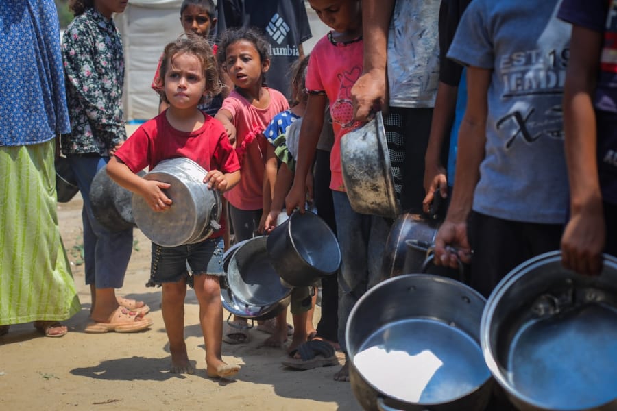 Des Palestiniens reçoivent des repas de la part de bénévoles dans la ville de Gaza, le 10 août 2025. (Photo : Ali Hassan/Flash90)